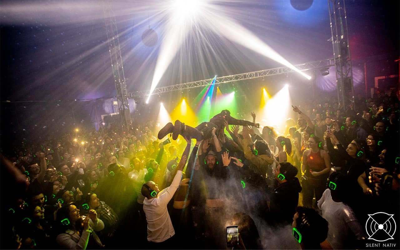 Espace silent disco dans un festival, casques lumineux dans la foule