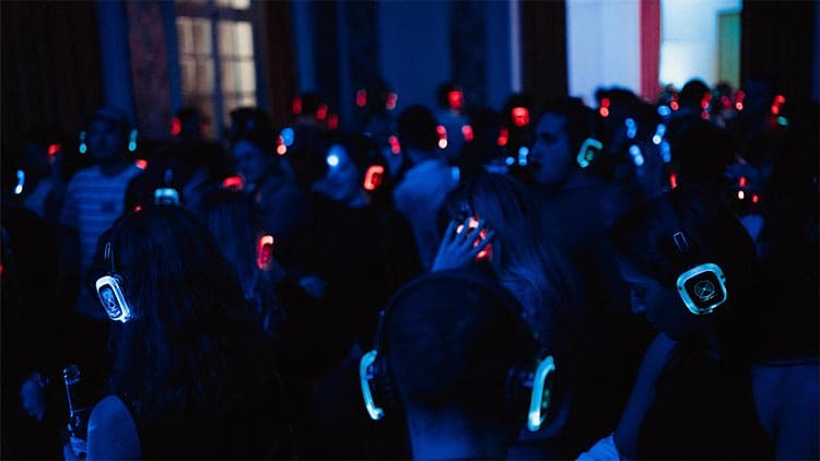 Foule de dos, casques allumés en rouge, vert et bleu